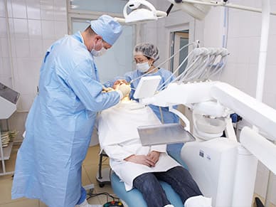 Стоматолог лечит пациента